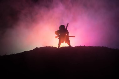 Savaşçı bir kılıç siluet bir gökyüzü ninja ile. Samuray koyu tonda sisli arka plan ile dağın zirvesinde. Seçici odak