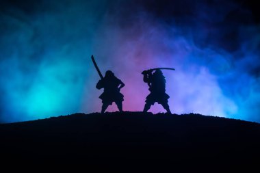 Düelloda iki samurais silüeti. İki samurais ve günbatımı gökyüzü ile hayal et. Seçici odak