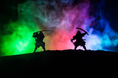 Düelloda iki samurais silüeti. İki samurais ve günbatımı gökyüzü ile hayal et. Seçici odak