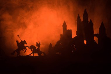 Medieval battle scene with cavalry and infantry. Silhouettes of figures as separate objects, fight between warriors on dark toned foggy background with old gothic castle clipart