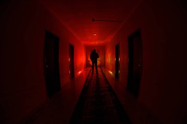 Ürpertici siluet koyu terk edilmiş binada. Manyak genel kavram ya da kabine kapılar ile karanlık koridor ve ışıkları ile farklı pozlar duran korkunç korku kişi silueti ile ilgili korku.