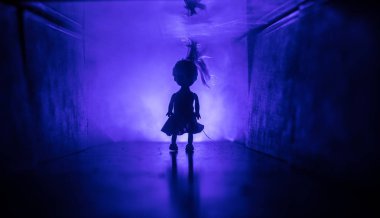 Ürpertici siluet koyu terk edilmiş binada. Korku manyak genel kavram ya da kabine kapılar ile karanlık koridor ve korkunç korku bebek ile farklı pozlar ayakta silüeti ışıklarla hakkında.