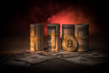 Bitcoin (sanal para) para ile toplu bize dolar koyu tonda sisli arka plan üzerinde. Seçici odak. Dijital para ve Bitcoin kavramı.