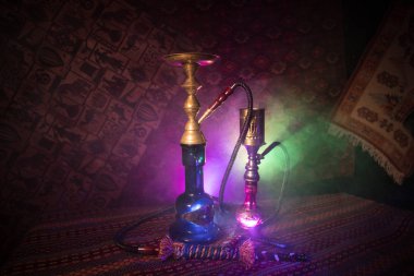 Nargile kömürü nargile kupa Arap iç de buhar bulutları yapma. Şark süsleme halı üzerinde. Şık oryantal shisha içinde karanlık arka ışık ile. Shisha reklam için. Seçici odak