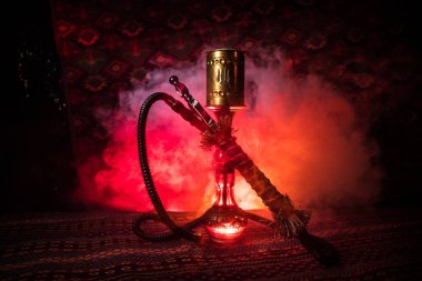 Nargile kömürü nargile kupa Arap iç de buhar bulutları yapma. Şark süsleme halı üzerinde. Şık oryantal shisha içinde karanlık arka ışık ile. Shisha reklam için. Seçici odak