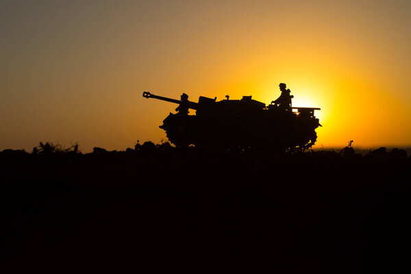War Concept. Military silhouettes fighting scene. World War German Tanks and soldiers silhouettes at sunset. Attack scene. Armored vehicles. Tanks battle