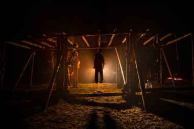 Korku görünümü siluet sis ile gece iskele üzerinde asılmış adam ve tonda ışık arka plan üzerinde. Yürütme (veya intihar) dekorasyon. Korku Cadılar Bayramı kavramı.