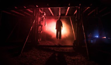 Korku görünümü siluet sis ile gece iskele üzerinde asılmış adam ve tonda ışık arka plan üzerinde. Yürütme (veya intihar) dekorasyon. Korku Cadılar Bayramı kavramı.