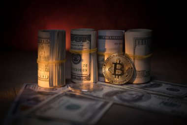 Bitcoin (sanal para) para ile toplu bize dolar koyu tonda sisli arka plan üzerinde. Seçici odak. Dijital para ve Bitcoin kavramı.