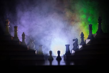 İş hiyerarşisi. Satranç taşları ile strateji kavramı. Kralın üst bir piramit kitapların üzerinde dururken satranç. Tonda ışık ile karanlık sisli arka plan. Kopya alanı.