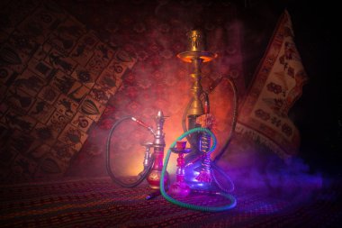 Nargile kömürü nargile kupa Arap iç de buhar bulutları yapma. Şark süsleme halı üzerinde. Şık oryantal shisha içinde karanlık arka ışık ile. Shisha reklam için. Seçici odak