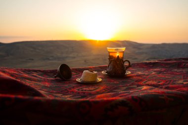 Doğu siyah çay bardağına Doğu halı. Doğu çay kavramı. Armudu geleneksel Kupası. Gün batımı arka plan. Seçici odak