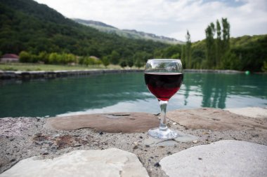 Havuz içinde uzun bardak içki. Ferahlık yaz gününde. Mor suyu kokteyl veya asma. Dağ orman arka plan. Seçici odak