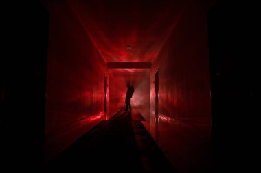 Ürpertici siluet koyu terk edilmiş binada. Manyak genel kavram ya da kabine kapılar ile karanlık koridor ve ışıkları ile farklı pozlar duran korkunç korku kişi silueti ile ilgili korku.
