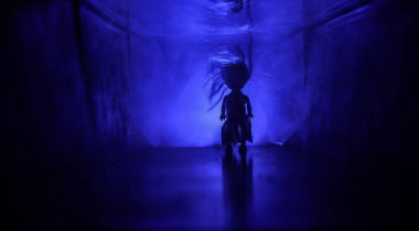 Ürpertici siluet koyu terk edilmiş binada. Korku manyak genel kavram ya da kabine kapılar ile karanlık koridor ve korkunç korku bebek ile farklı pozlar ayakta silüeti ışıklarla hakkında.