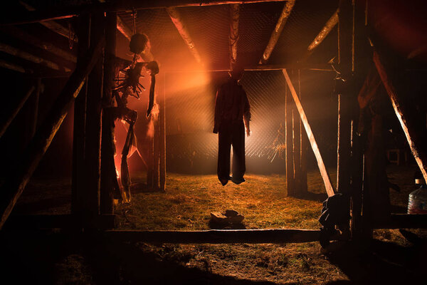 Horror view silhouette of hanged man on scaffold at night with fog and toned light on background. Execution (or suicide) decoration. Horror Halloween concept.