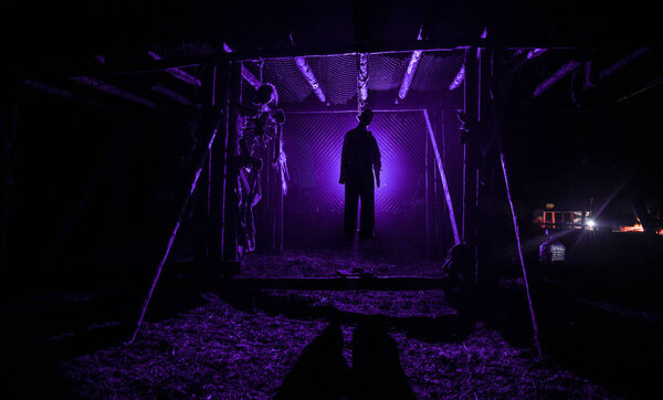 Horror view silhouette of hanged man on scaffold at night with fog and toned light on background. Execution (or suicide) decoration. Horror Halloween concept.