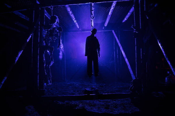 Horror view silhouette of hanged man on scaffold at night with fog and toned light on background. Execution (or suicide) decoration. Horror Halloween concept.
