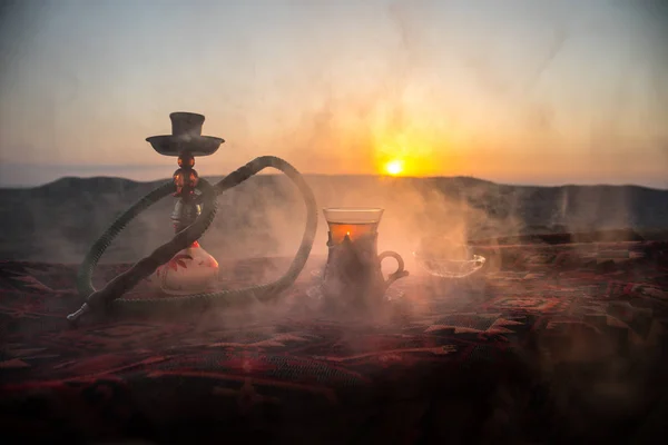 水ギセル ホット石炭シーシャ ボウル砂漠で蒸気の雲を屋外に作る カーペット東部茶道に東洋の飾り 夕日を背景にスタイリッシュな東洋の使者 選択と集中 — ストック写真