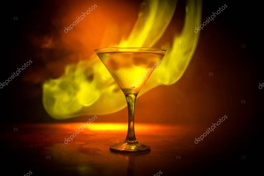 Martini en concepto de fuego. Vaso de famoso cóctel Martini ardiendo en