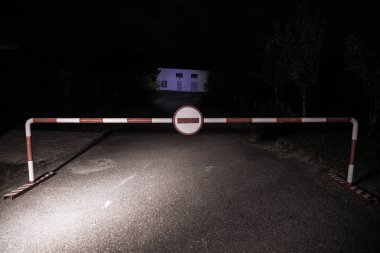 Yanlış yöne kavramı. Bariyer ile gece bir giriş oturum açın. Bariyer ayakta yolda korkunç hayaletler ya da manyak ile bina perili. Tehlikeli bölge hakkında uyarı