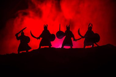 Dört Ortaçağ savaşçıları savaşmaya hazır silüeti. Karanlık kılıçla ile dört fighter resimle sisli arka plan tonda. Seçici odak.