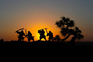 Düelloda dört samurais silüeti. İki samurais ve günbatımı gökyüzü ile hayal et. Seçici odak