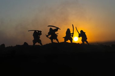 Düelloda dört samurais silüeti. İki samurais ve günbatımı gökyüzü ile hayal et. Seçici odak