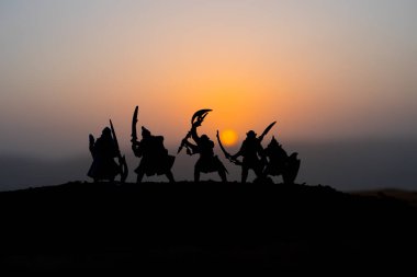 Ortaçağ savaş sahnesi günbatımı üzerinde. Siluetleri savaşçılar günbatımı arka plan üzerinde mücadele. Seçici odak