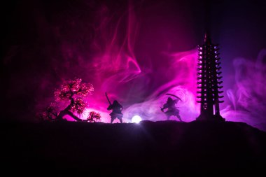 Samuray dövüş konsepti. Samuray silueti, ağaç ve eski tapınağın yanında düelloda. Masa dekorasyonu koyu renkli sisli arka plan. Seçici odak