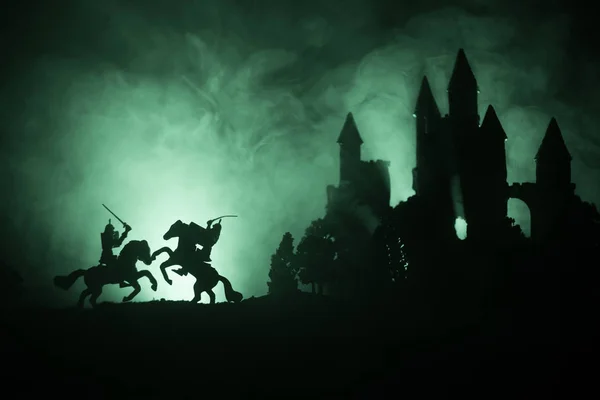 中世纪战斗场面与骑兵和步兵 图的剪影作为分开的对象 战斗在黑暗的柔和的有雾背景的战士之间与老哥特式的城堡 — 图库照片