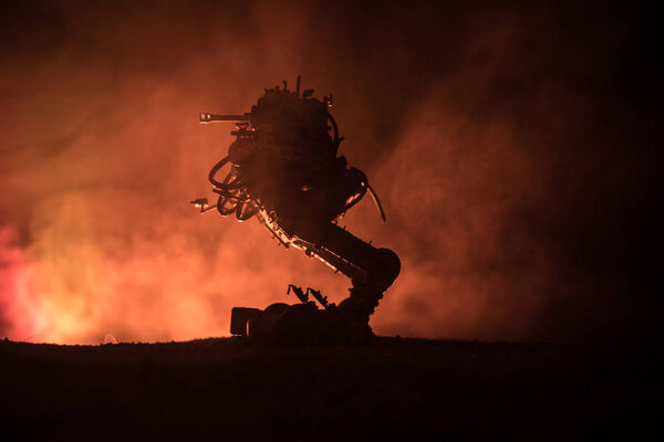 Silhouette of Giant robot. Futuristic tank in action with foggy fire sky background. Combat vehicle.