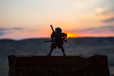 Savaşçı bir kılıç siluet bir gökyüzü ninja ile. Samuray koyu tonda sisli arka plan ile dağın zirvesinde. Seçici odak