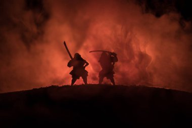 Düelloda iki samurais silüeti. İki samurais ve günbatımı gökyüzü ile hayal et. Seçici odak