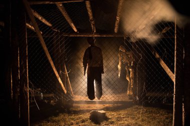 Korku görünümü siluet sis ile gece iskele üzerinde asılmış adam ve tonda ışık arka plan üzerinde. Yürütme (veya intihar) dekorasyon. Korku Cadılar Bayramı kavramı.