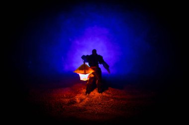 Yağmurluk ile onun el kavramı içinde parlayan fener karanlık ormanın gelen adam. Lamba korku katille silüeti. Dekorasyon