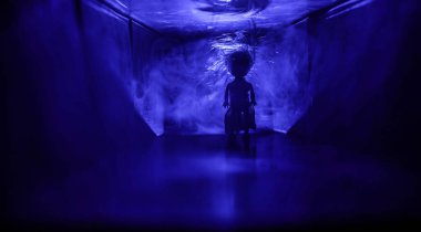 Ürpertici siluet koyu terk edilmiş binada. Korku manyak genel kavram ya da kabine kapılar ile karanlık koridor ve korkunç korku bebek ile farklı pozlar ayakta silüeti ışıklarla hakkında.