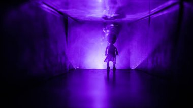 Ürpertici siluet koyu terk edilmiş binada. Korku manyak genel kavram ya da kabine kapılar ile karanlık koridor ve korkunç korku bebek ile farklı pozlar ayakta silüeti ışıklarla hakkında.