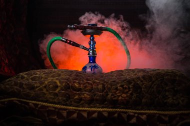 Nargile kömürü nargile kupa Arap iç de buhar bulutları yapma. Şark süsleme halı üzerinde. Şık oryantal shisha aydınlatmalı. Shisha reklam için. Seçici odak
