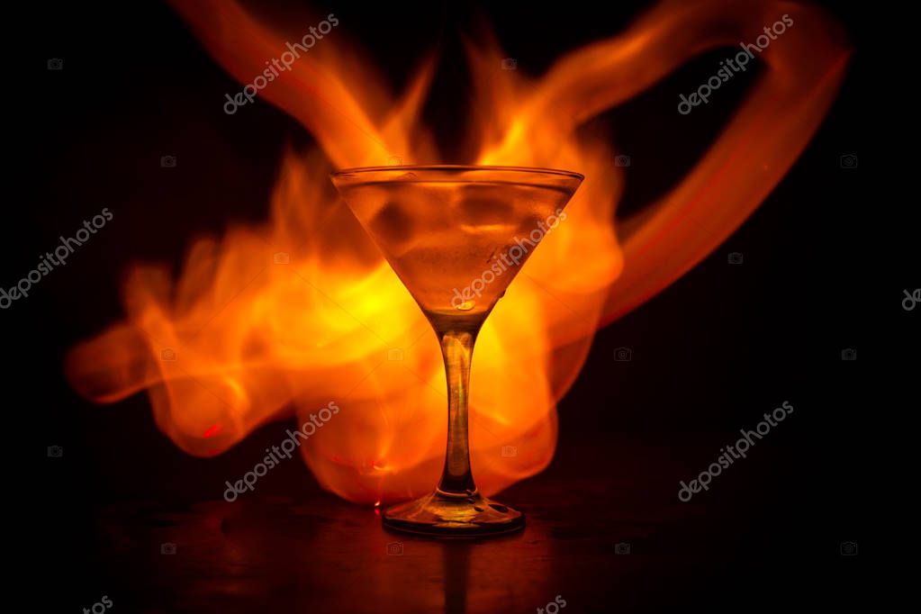 Martini en concepto de fuego. Vaso de famoso cóctel Martini ardiendo en