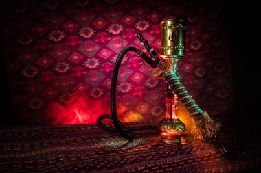 Nargile kömürü nargile kupa Arap iç de buhar bulutları yapma. Şark süsleme halı üzerinde. Şık oryantal shisha içinde karanlık arka ışık ile. Shisha reklam için. Seçici odak