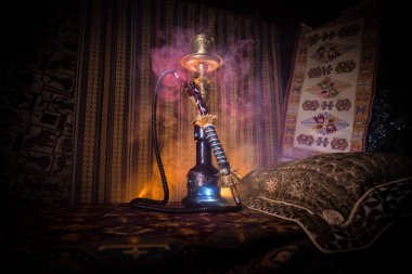 Nargile kömürü nargile kupa Arap iç de buhar bulutları yapma. Şark süsleme halı üzerinde. Şık oryantal shisha içinde karanlık arka ışık ile. Shisha reklam için. Seçici odak