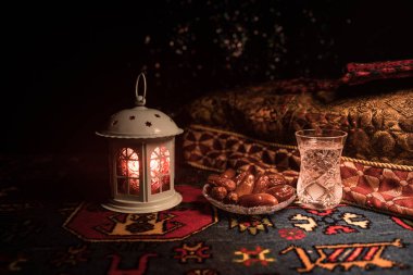 Water and dates. Iftar is the evening meal. View of decoration Ramadan Kareem holiday on carpet. Festive greeting card, invitation for Muslim holy month Ramadan Kareem. Selective focus clipart