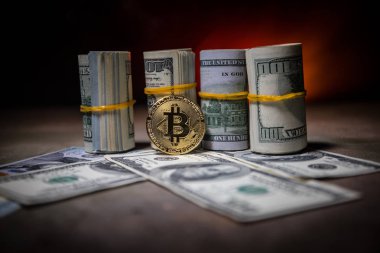 Bitcoin (sanal para) para ile toplu bize dolar koyu tonda sisli arka plan üzerinde. Seçici odak. Dijital para ve Bitcoin kavramı.