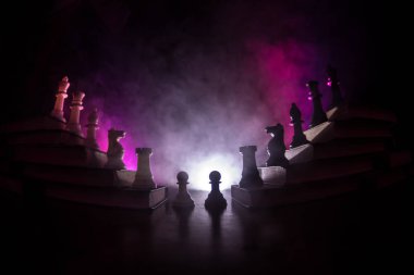 İş hiyerarşisi. Satranç taşları ile strateji kavramı. Kralın üst bir piramit kitapların üzerinde dururken satranç. Tonda ışık ile karanlık sisli arka plan. Kopya alanı.