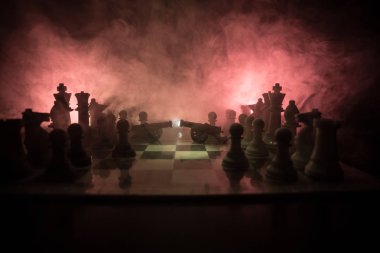 Satranç tahtası üzerinde iki top ile ortaçağ savaş sahnesi. Satranç oyununu kavramı iş fikirleri ve rekabet ve strateji fikirler duman ve sis karanlık bir arka plan üzerinde satranç figürleri.