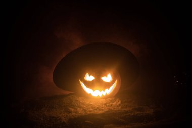 Cadılar Bayramı kavramı. Jack-o-lantern gülümseme ve gece parti için korkutucu gözler. Korkutucu Kabak cadı Karanlık sisli arka plan, şapkası ile görünümünü kapatın. Seçici odak. Boş alan