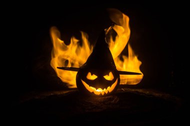 Cadılar Bayramı kavramı. Jack-o-lantern gülümseme ve gece parti için korkutucu gözler. Korkutucu Kabak cadı Karanlık sisli arka plan, şapkası ile görünümünü kapatın. Seçici odak. Boş alan