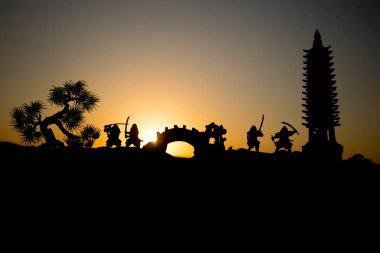 Savaşçı bir kılıç siluet bir gökyüzü ninja ile. Samuray koyu tonda sisli arka plan ile dağın zirvesinde. Seçici odak