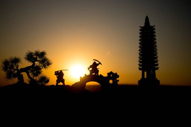 Savaşçı bir kılıç siluet bir gökyüzü ninja ile. Samuray koyu tonda sisli arka plan ile dağın zirvesinde. Seçici odak